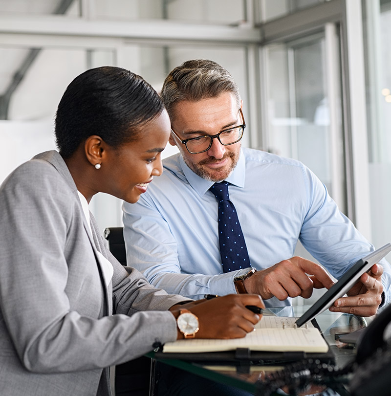 Two individuals using a tablet and working together on grant funding support