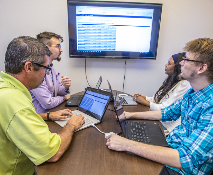 Two CCI Systems Workers Looking at a Laptop